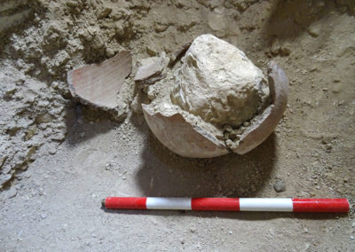 Al fondo del pozo que excavan David y Ana aparece una cerámica del Reino Medio que fue rota por la caída de una piedra.
