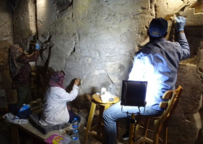 El equipo de restauradores egipcios limpia a fondo una de las paredes de la sala transversal.