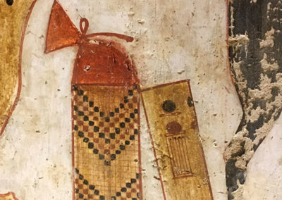 Equipo de escriba debajo de la silla de Mena: una paleta de escriba, con tinta negra y roja y la ranura para pinceles, junto a una cesta que contendría uno o más papiros.