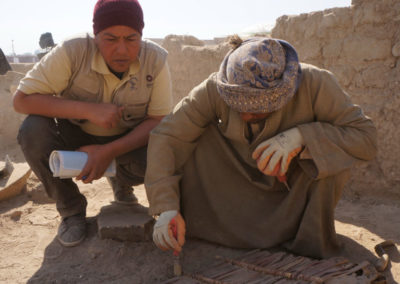 El Inspector Abdelgani sigue con atención cómo Ibrahim excava la planchas de cañas y fibra vegetal.