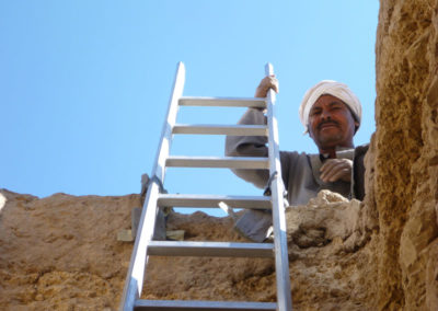 Yuma sujeta la escalera en lo alto del pozo que él excava con José Miguel.