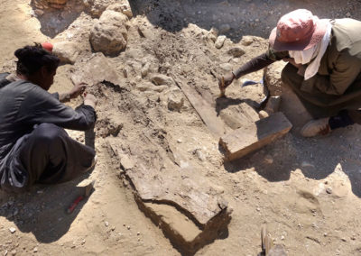 Saabut y Gamal excavan los restos de un expolio, incluyendo la tapa de un ataúd de la dinastía XIII.