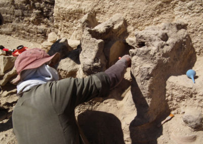 Gamal excava con precisión en el interior de una capilla de adobe adosada a la roca.