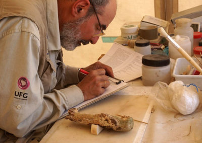 José Miguel trata de leer la inscripción muy dañada de un shabti de madera.