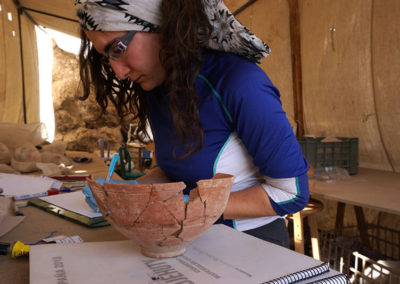 María dibuja cerámica en la jaima grande.