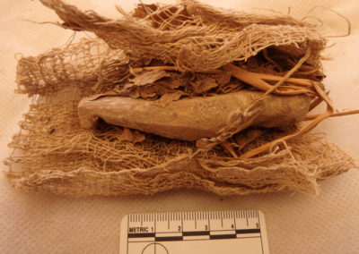 Shabti de madera envuelto en lino y en hojas, tal vez de persea.