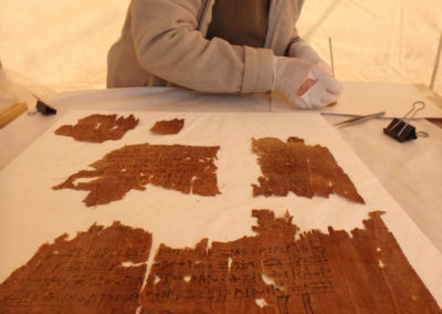 Pía revisa y completa la conservación de un lino con inscripción del año pasado.