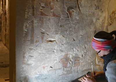 Carmen dibuja de cara a la pared dentro de la capilla de Djehuty.