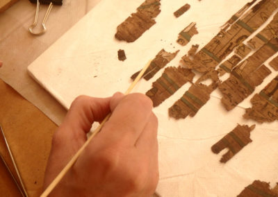 Lucía retoca el montaje de un papiro con el Libro de los Muertos hallado por David el año pasado.