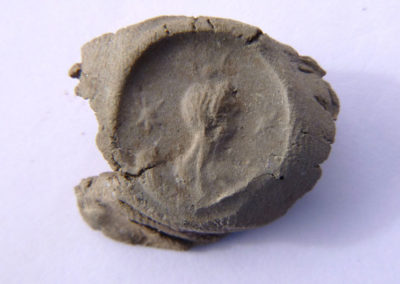 Impronta de sello, probablemente con la efigie de la diosa Isis sobre la luna y entre dos estrellas.