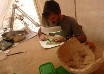 Guillem revisa el contenido de una vasija procedente de la excavación de Carlos dentro de la gran tumba.