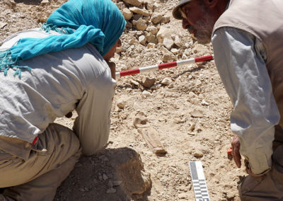 Laura y José Miguel observan y discuten sobre la tapa de ataúd de shabti aparecida en la excavación.