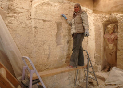 Fatma limpia la fachada de la tumba de Djehuty, después de haber puesto por encima un capa de “hiba” y otra de mortero.