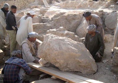 Ali y algunos trabajadores se esfuerzan en retirar una gran piedra del área que excava José Miguel.
