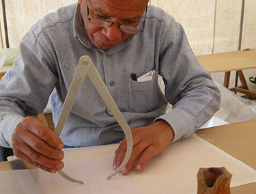 Ayad dibuja cerámica dentro de la jaima grande.