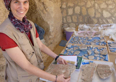 Lucía pega fragmentos de estuco con restos de texto del Libro de los Muertos de Djehuty.