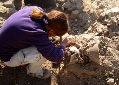 Elena se acerca a la excavación para examinar in situ una cerámica.