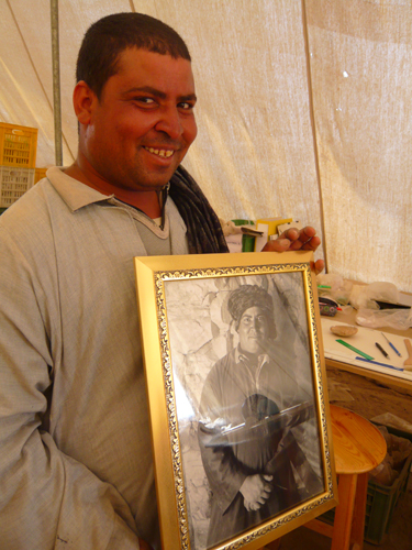 Taalat muestra encantado un retrato que le ha hecho y enmarcado Pito.