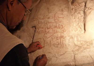 Mohamed limpia y consolida grafiti demóticos en el pasillo de Djehuty.
