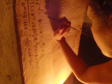 Lucía practica con un restaurador del equipo belga cómo se debieron escribir las paredes de la cámara sepulcral de Djehuty.