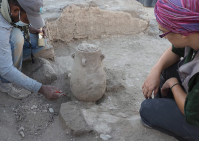 María observa atentamente cómo Bahba excava alrededor dela vasija.