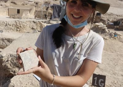 Laura muestra el ostracon hallado en su área de excavación.