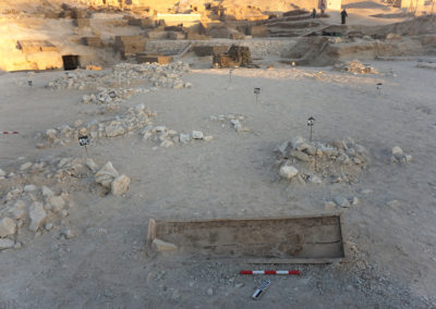 Ataúd del Reino Medio caído sobre el suelo de los túmulos de piedra.