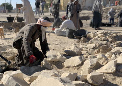 Ahmed excava entre los bloques de piedra arrojados fuera por los saqueadores antiguos.