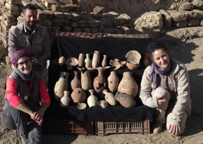 David, María y Zulema posan junto a un conjunto de cerámicas procedentes del pozo de las sandalias de cuero.