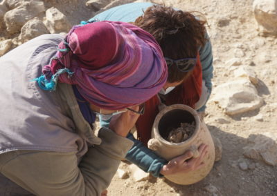 Zulema y María observan el interior de la vasija, utilizada en el proceso de momificación.