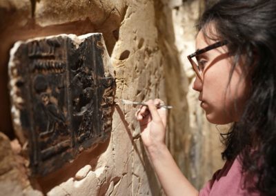 Blanca colocando mortero para fijar los fragmentos de relieve restauarados en la tumba de Djehuty.